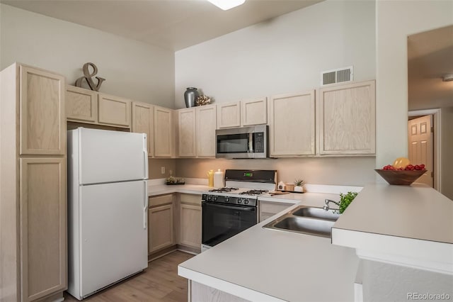 9911 E Idaho Cir Unit 202, Denver, CO 80247 - kitchen featuring freestanding refrigerator, stainless steel microwave, range with gas stovetop, and light brown cabinetry