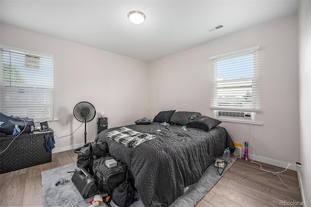 bedroom with cooling unit and hardwood / wood-style floors