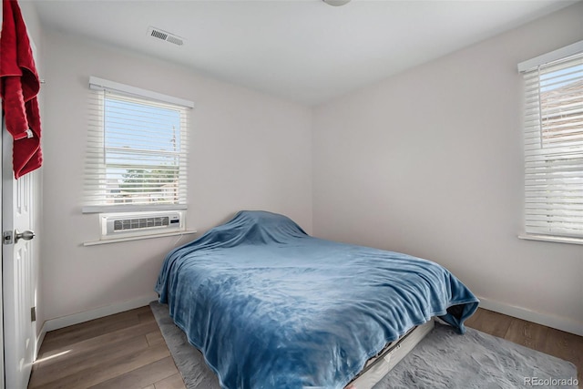 bedroom with light hardwood / wood-style floors and cooling unit