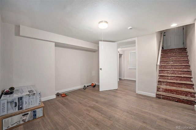 basement with wood-type flooring and a textured ceiling