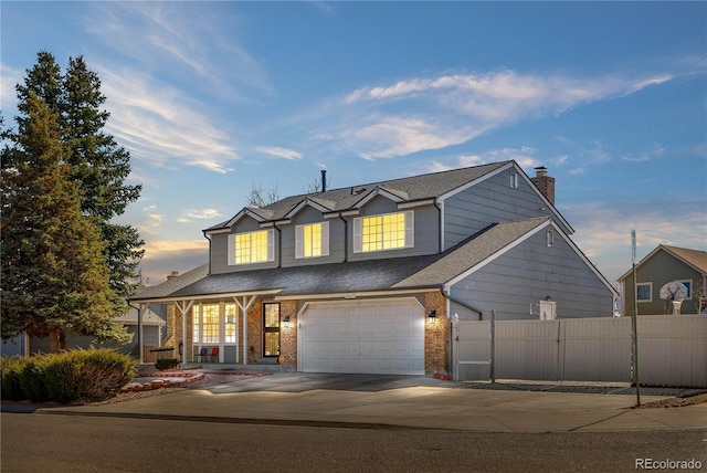 traditional-style home with a garage, brick siding, fence, driveway, and a chimney