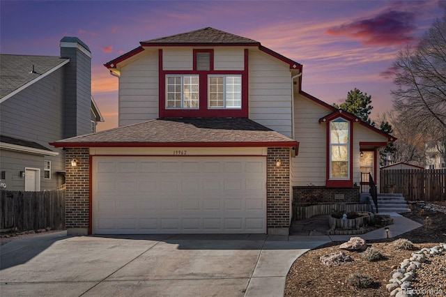 traditional-style house featuring fence, concrete driveway, and brick siding