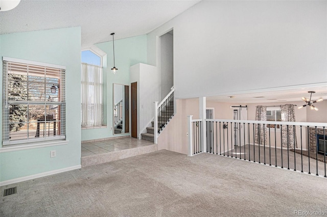 spare room with visible vents, stairway, carpet flooring, high vaulted ceiling, and a notable chandelier