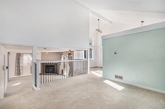 unfurnished living room featuring carpet floors, beam ceiling, visible vents, and baseboards