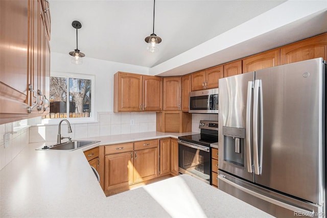 kitchen featuring light countertops, hanging light fixtures, decorative backsplash, appliances with stainless steel finishes, and a sink