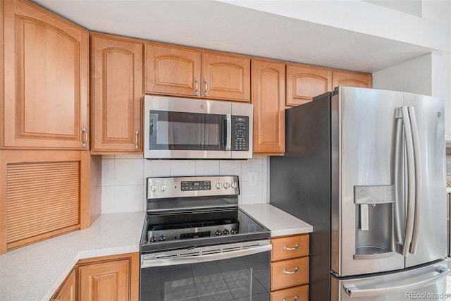 kitchen featuring light countertops, appliances with stainless steel finishes, and decorative backsplash