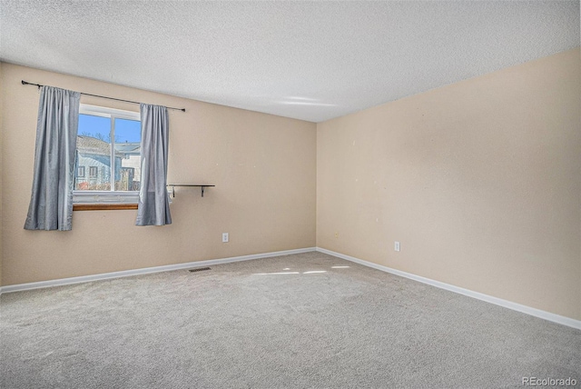 unfurnished room featuring carpet floors, visible vents, baseboards, and a textured ceiling