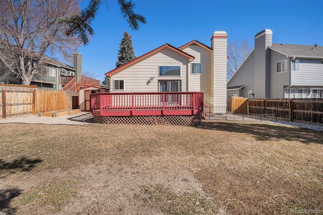 back of property with a yard, a fenced backyard, and a wooden deck