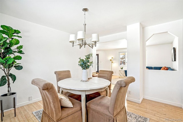 dining space featuring a notable chandelier and light hardwood / wood-style flooring