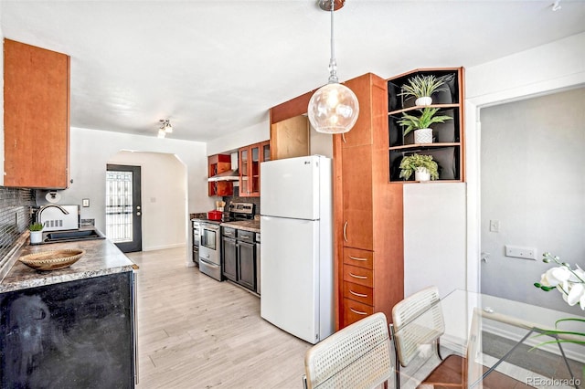 kitchen featuring pendant lighting, sink, stainless steel range with electric stovetop, white refrigerator, and wall chimney exhaust hood