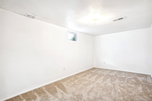 carpeted spare room featuring a textured ceiling