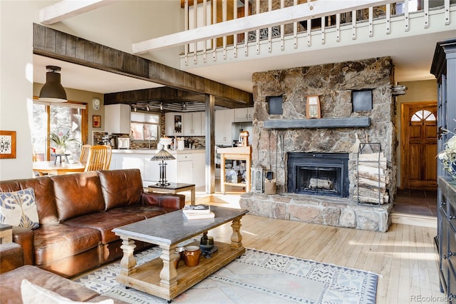 living room with hardwood / wood-style flooring, sink, a fireplace, and beam ceiling