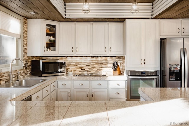 kitchen featuring appliances with stainless steel finishes, sink, white cabinets, and decorative backsplash