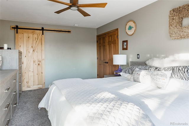 carpeted bedroom featuring ceiling fan and a barn door