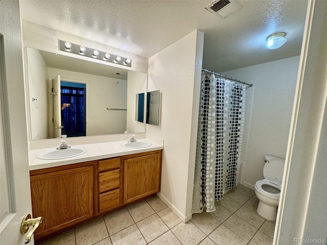 7440 S Blackhawk St Unit 208, Englewood, CO 80112 - bathroom with tile patterned floors, toilet, double vanity, a textured ceiling, and curtained shower