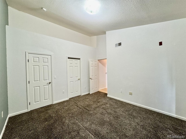 7440 S Blackhawk St Unit 208, Englewood, CO 80112 - unfurnished bedroom featuring dark carpet, baseboards, a textured ceiling, and lofted ceiling
