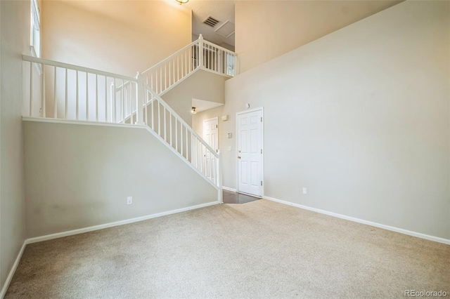 2446 S Gibralter Way, Aurora, CO 80013 - unfurnished living room with carpet flooring, stairway, and a towering ceiling
