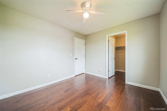 2446 S Gibralter Way, Aurora, CO 80013 - unfurnished bedroom with dark wood finished floors, a spacious closet, ceiling fan, and a closet