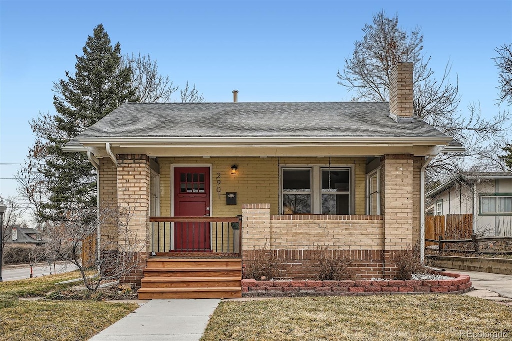 2901 Ames St, Wheat Ridge, CO 80214 - bungalow-style home featuring fence, roof with shingles, covered porch, a chimney, and brick siding