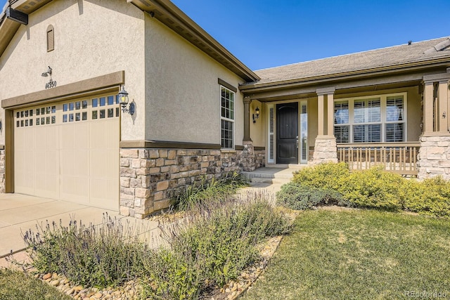 16550 Antero Cir, Broomfield, CO 80023 - property entrance featuring stone siding, a garage, stucco siding, concrete driveway, and a porch