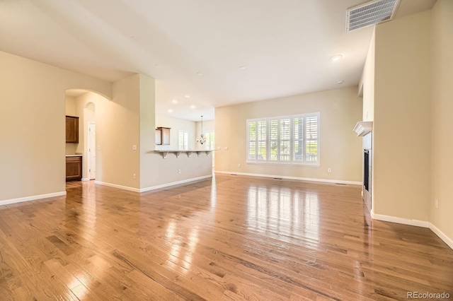 16550 Antero Cir, Broomfield, CO 80023 - unfurnished living room with light wood-type flooring, a fireplace, arched walkways, and recessed lighting