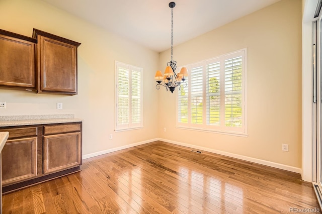 16550 Antero Cir, Broomfield, CO 80023 - unfurnished dining area with a chandelier, wood finished floors, and plenty of natural light