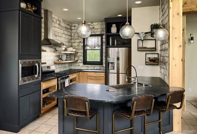 kitchen featuring a kitchen breakfast bar, decorative light fixtures, stainless steel appliances, wall chimney range hood, and open shelves