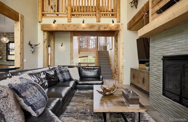 living area featuring a towering ceiling, a fireplace, and stairway