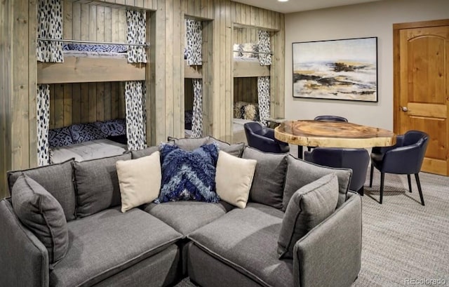 living room with wood walls and light colored carpet