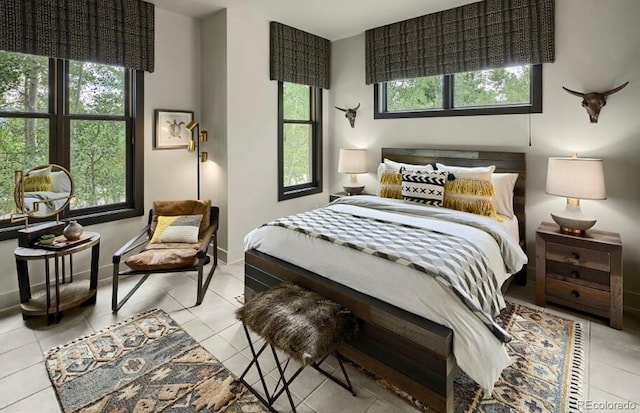 bedroom with light tile patterned floors, multiple windows, and baseboards