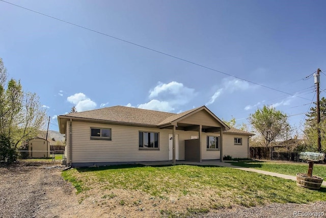 ranch-style home with a front lawn and fence