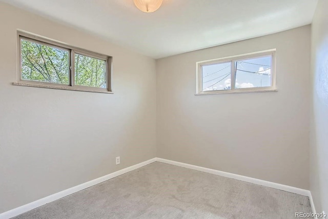 carpeted empty room with baseboards and a wealth of natural light