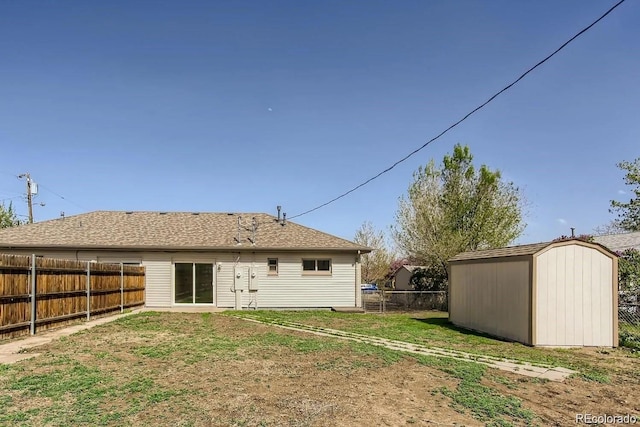 back of house with a storage shed, a fenced backyard, a lawn, and an outdoor structure