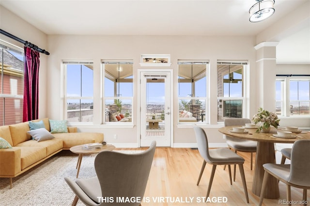 1975 Wild Star Way, Castle Rock, CO 80104 - living room with light wood-style flooring, baseboards, and ornate columns