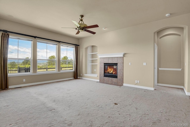 1975 Wild Star Way, Castle Rock, CO 80104 - unfurnished living room with ceiling fan, a tile fireplace, baseboards, built in shelves, and carpet flooring