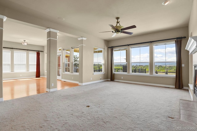 1975 Wild Star Way, Castle Rock, CO 80104 - unfurnished living room featuring light carpet, ceiling fan, plenty of natural light, and baseboards