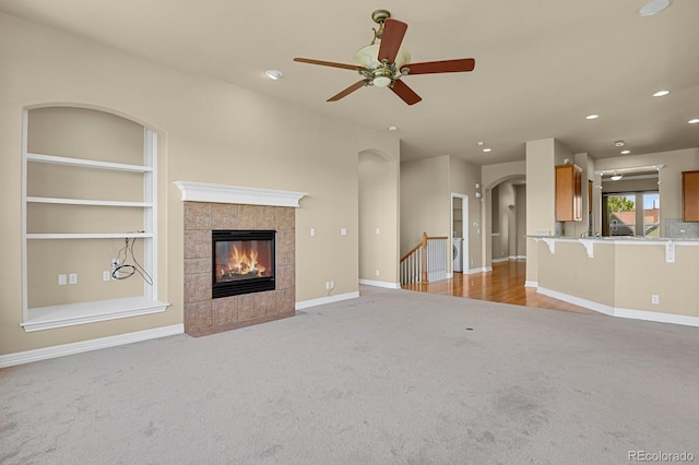 1975 Wild Star Way, Castle Rock, CO 80104 - unfurnished living room featuring light colored carpet, ceiling fan, recessed lighting, baseboards, and a tile fireplace
