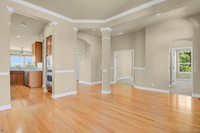 1975 Wild Star Way, Castle Rock, CO 80104 - unfurnished living room with arched walkways, light wood-type flooring, baseboards, decorative columns, and crown molding