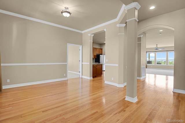 1975 Wild Star Way, Castle Rock, CO 80104 - unfurnished living room with arched walkways, ornate columns, light wood-type flooring, baseboards, and ornamental molding