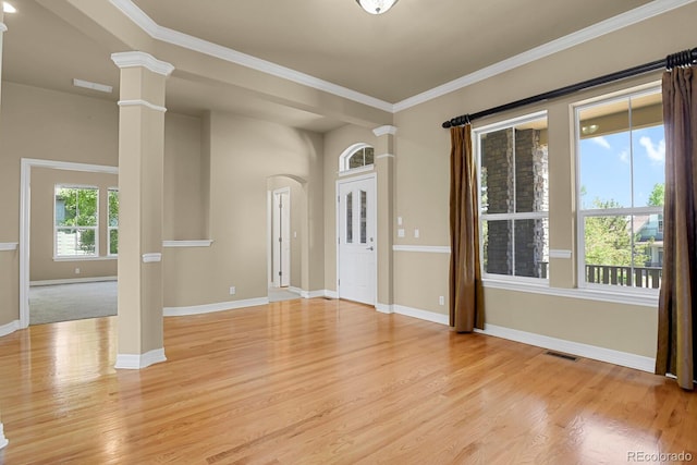 1975 Wild Star Way, Castle Rock, CO 80104 - empty room with light wood-style flooring, arched walkways, baseboards, ornate columns, and ornamental molding