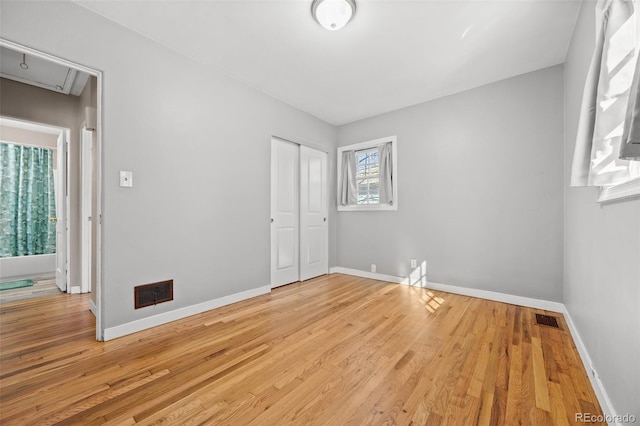 unfurnished bedroom with visible vents, baseboards, and wood finished floors