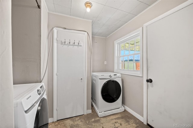 laundry area featuring laundry area, washing machine and dryer, baseboards, and crown molding