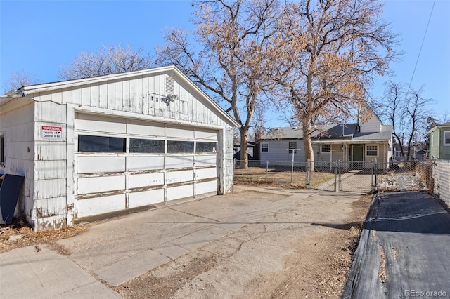 detached garage featuring fence and a gate