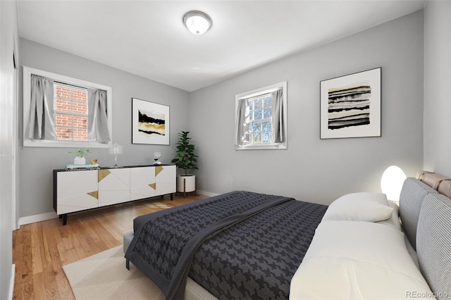 bedroom with light wood-style flooring and baseboards