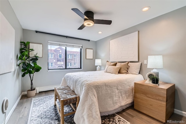 bedroom featuring baseboards, ceiling fan, a baseboard radiator, light wood-style flooring, and recessed lighting