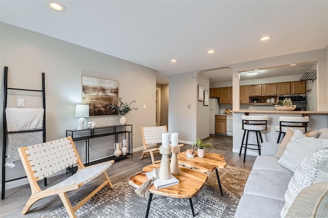 living area with wood finished floors, recessed lighting, and baseboards