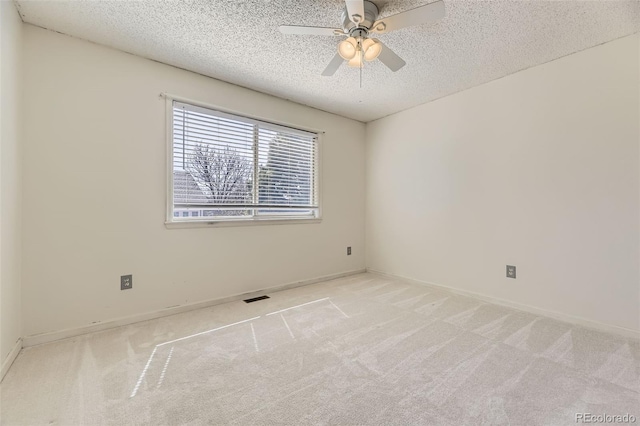 empty room with visible vents, ceiling fan, carpet, and a textured ceiling