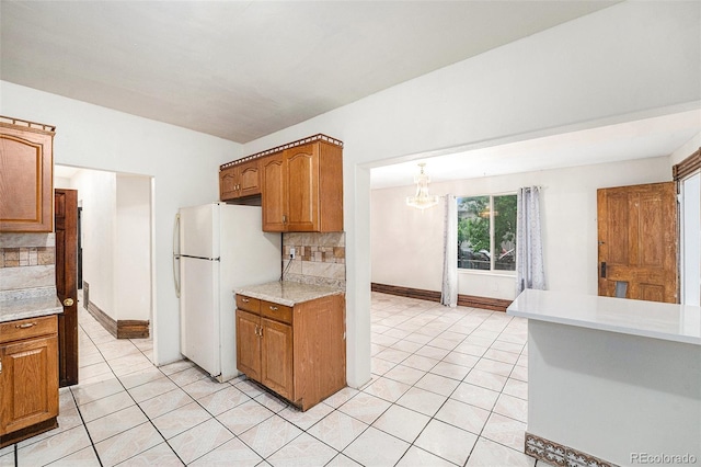 7 Elati St, Denver, CO 80223 - kitchen featuring freestanding refrigerator, light tile patterned floors, a chandelier, and decorative backsplash