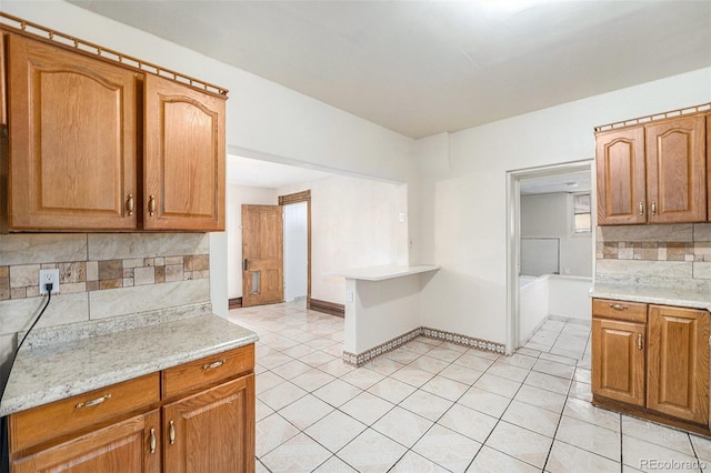 7 Elati St, Denver, CO 80223 - kitchen with decorative backsplash, light tile patterned flooring, and brown cabinetry