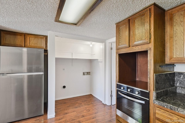 kitchen featuring hardwood / wood-style flooring, appliances with stainless steel finishes, and a textured ceiling